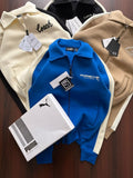 Collection of branded jackets with visible logos on a wooden surface