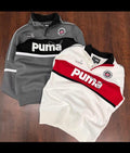 Gray and white Puma sweatshirt and red and white Puma polo shirt on a wooden surface
