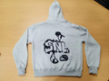 Gray hoodie with black graphic design on a wooden surface