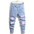 Light blue distressed jeans with pink patches on a white background